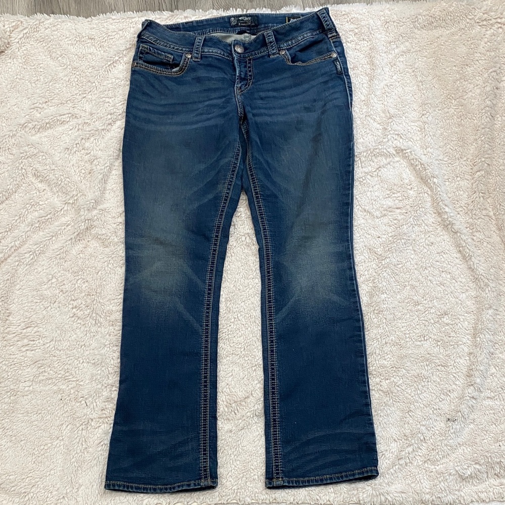 Silver Jeans Co. Suki Mid Rise Curvy Fit Bootcut jeans in a mid wash.